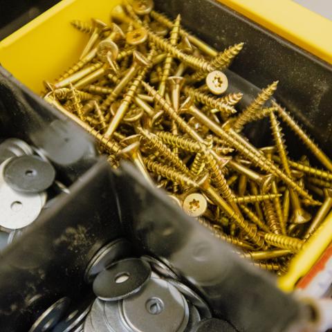 Three boxes beside each other, each filled with different nuts and bolts 